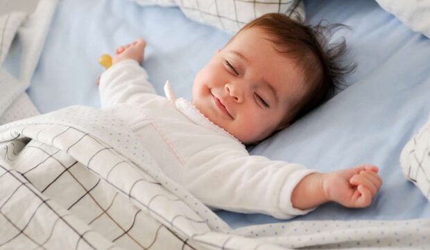 image-1692944591___smiling-baby-lying-bed-pic_32ratio_900x600-900x600-86511