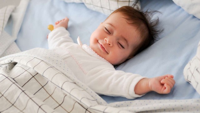 image-1692944591___smiling-baby-lying-bed-pic_32ratio_900x600-900x600-86511